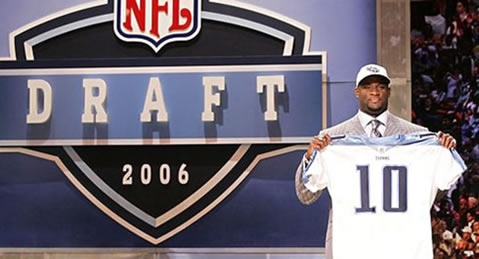 Vince Young holds up the jersey of his new team